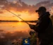 ماهیگیر حرفه‌ای در حال پرتاب طعمه زنده در غروب آفتاب برای صید موفق در دریاچه